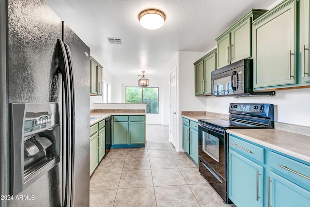 kitchen featuring green cabinets, light tile patterned floors, and black appliances