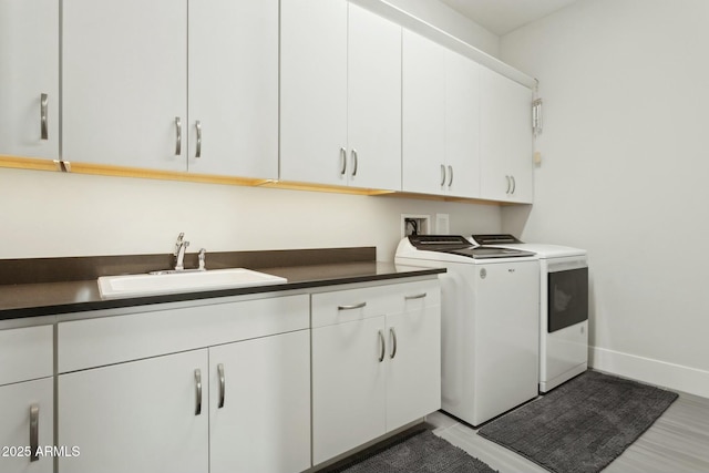 laundry room featuring washer and dryer, sink, and cabinets