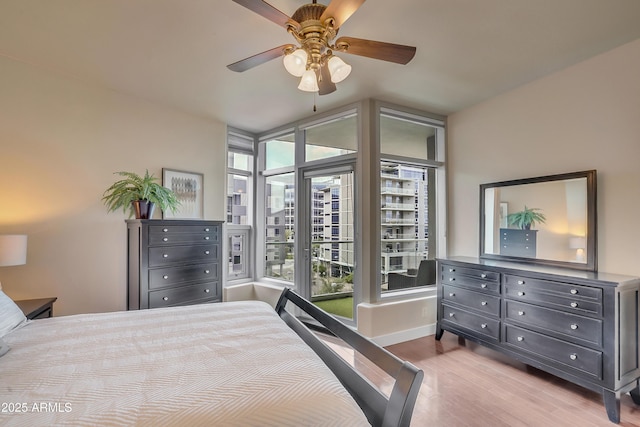 bedroom featuring baseboards, a ceiling fan, and wood finished floors