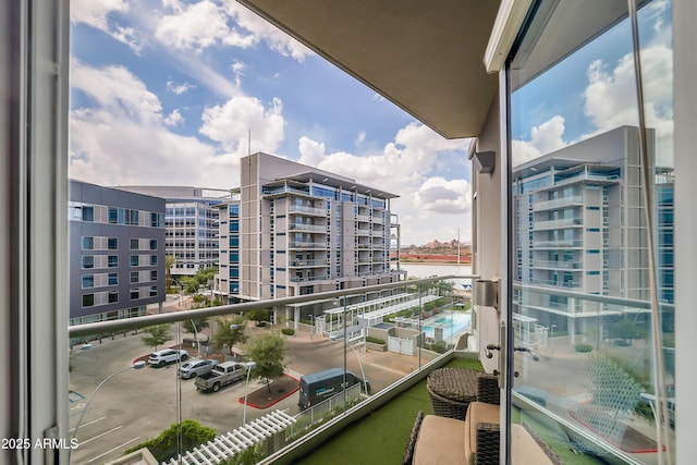 balcony with a water view and a view of city