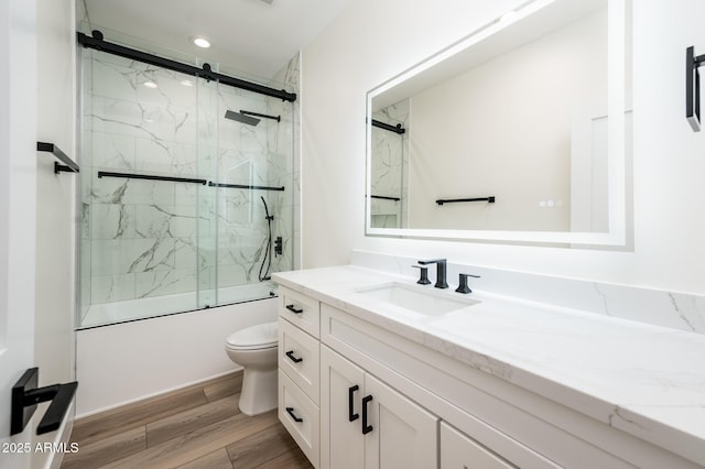 full bathroom featuring toilet, vanity, and shower / bath combination with glass door