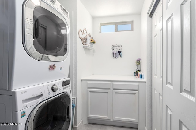 6701 W Catalina Dr, Phoenix, AZ 85033 - laundry area with stacked washer and dryer, cabinet space, and light tile patterned floors