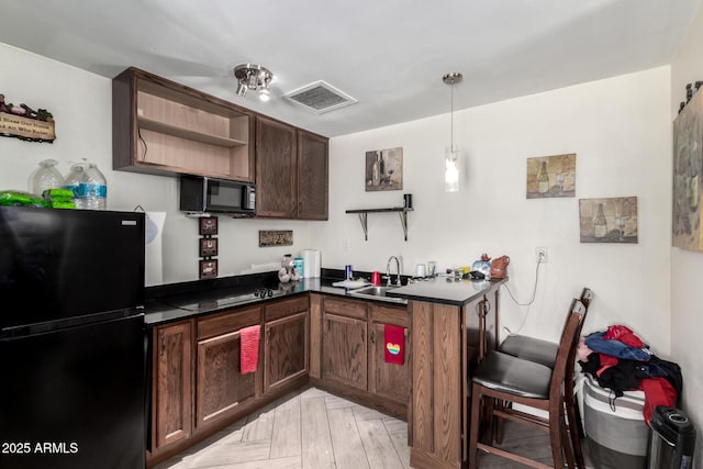 6701 W Catalina Dr, Phoenix, AZ 85033 - kitchen with visible vents, open shelves, dark countertops, a sink, and black appliances