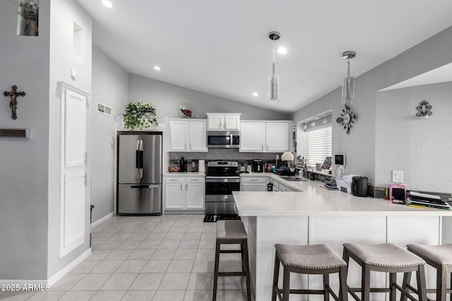 6701 W Catalina Dr, Phoenix, AZ 85033 - kitchen with appliances with stainless steel finishes, a breakfast bar area, a peninsula, light tile patterned floors, and lofted ceiling
