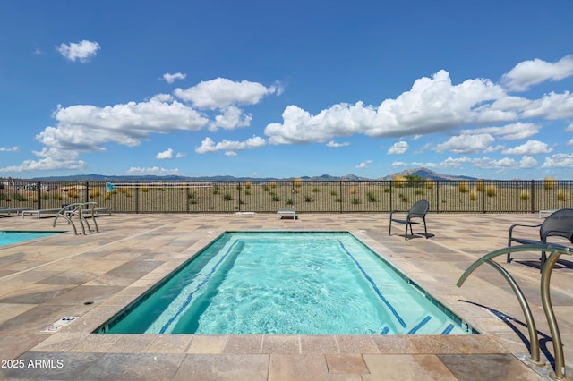 view of swimming pool with a mountain view and a patio