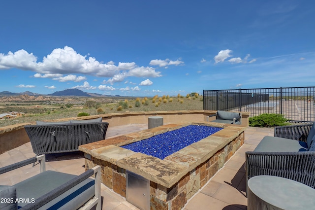 view of patio / terrace with a mountain view and an outdoor fire pit