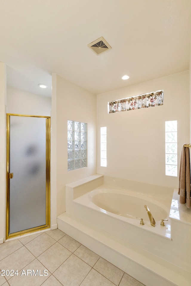 bathroom featuring independent shower and bath, a wealth of natural light, and tile patterned floors