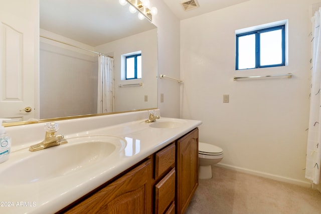 bathroom featuring vanity, toilet, and curtained shower