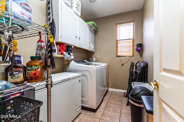 laundry area with baseboards, cabinet space, washing machine and clothes dryer, and light tile patterned floors