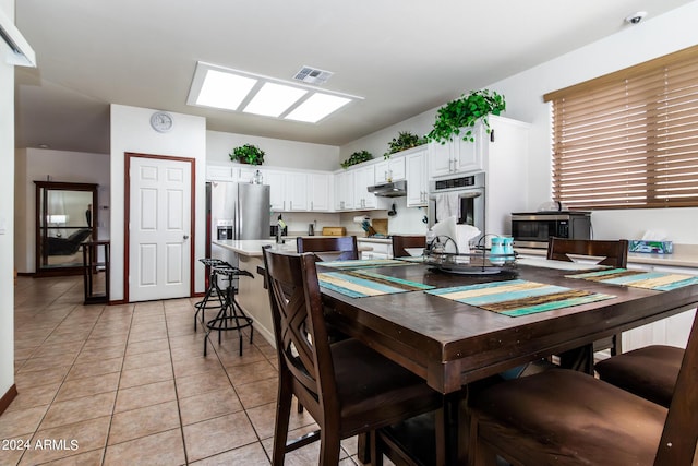 dining area featuring visible vents and light tile patterned flooring