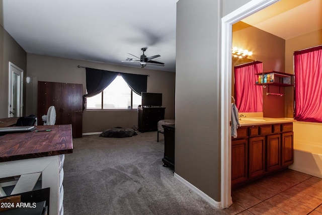 interior space with tile patterned floors, ceiling fan, baseboards, and vanity