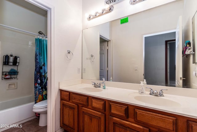 bathroom with toilet, tile patterned flooring, double vanity, and a sink