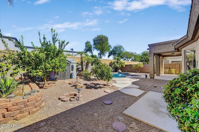 view of yard with a fenced in pool, a patio area, and a storage shed