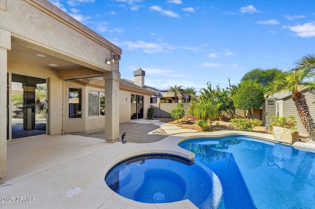 view of swimming pool featuring an in ground hot tub and a patio area