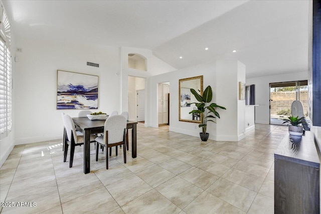 tiled dining space featuring lofted ceiling