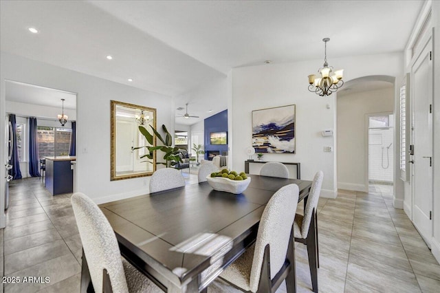 dining room featuring vaulted ceiling and ceiling fan with notable chandelier