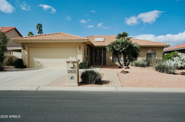 view of front of property featuring a garage, a tile roof, driveway, and stucco siding