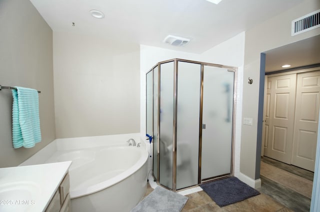 bathroom with vanity, a stall shower, a garden tub, and visible vents