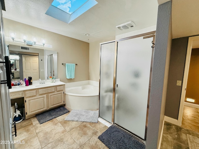 full bathroom featuring a skylight, visible vents, a stall shower, vanity, and a bath