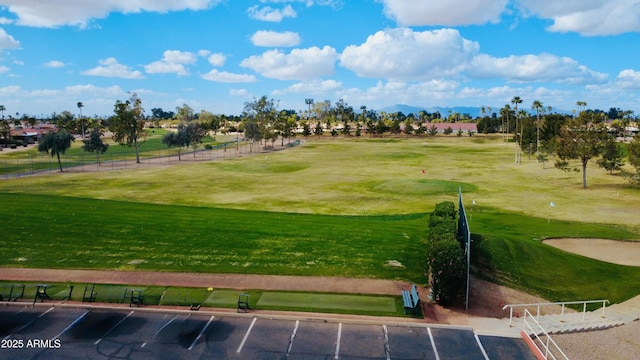 view of community featuring fence, golf course view, and a yard