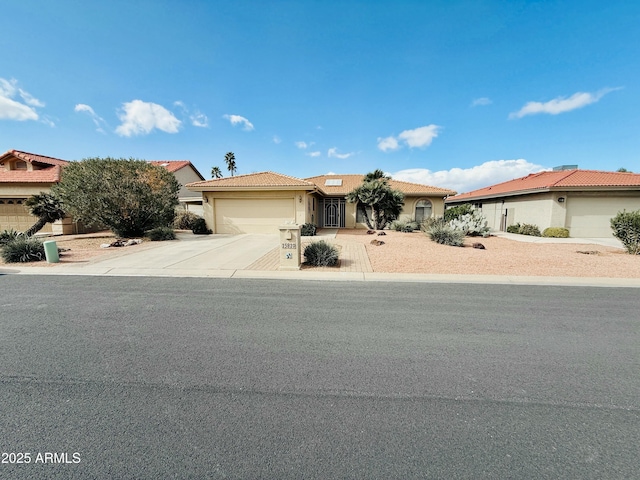 view of front of property with a garage, a tiled roof, concrete driveway, and stucco siding