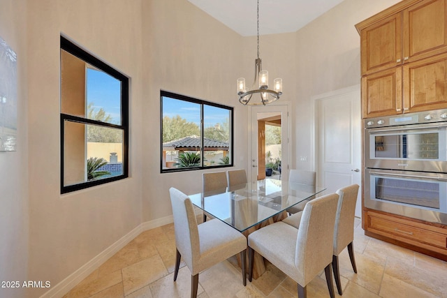 dining area featuring a high ceiling and a notable chandelier