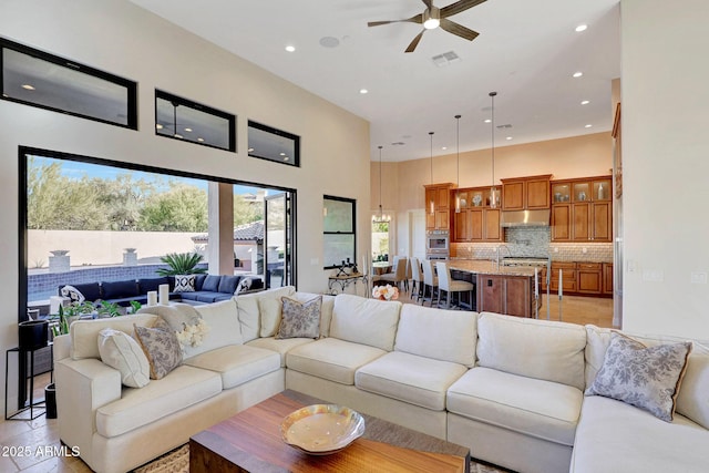 living room featuring a high ceiling and ceiling fan