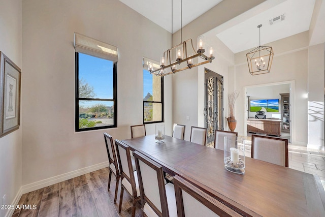 dining space with an inviting chandelier and light hardwood / wood-style flooring