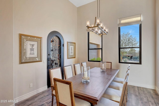 dining space featuring wood-type flooring and a chandelier