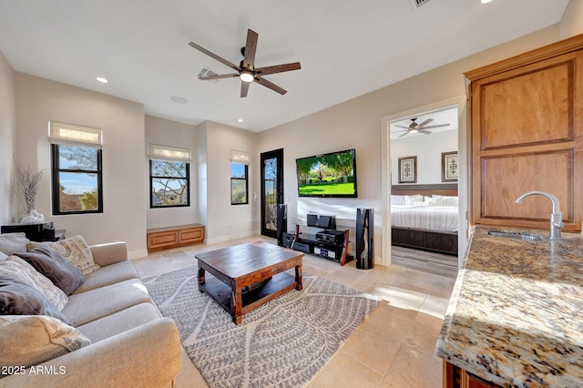 living room featuring sink, ceiling fan, a healthy amount of sunlight, and light tile patterned floors