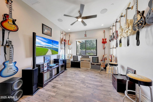 living room featuring ceiling fan and light hardwood / wood-style flooring