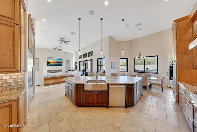 kitchen with a kitchen island with sink, pendant lighting, and sink