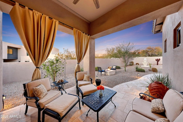 patio terrace at dusk with an outdoor hangout area and ceiling fan