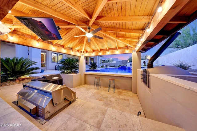 view of patio featuring an outdoor kitchen, exterior bar, and ceiling fan