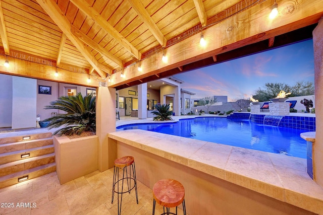 pool at dusk featuring pool water feature