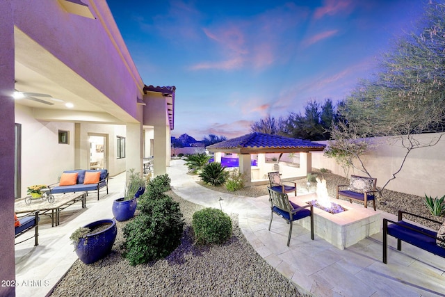 patio terrace at dusk featuring a gazebo and an outdoor living space with a fire pit