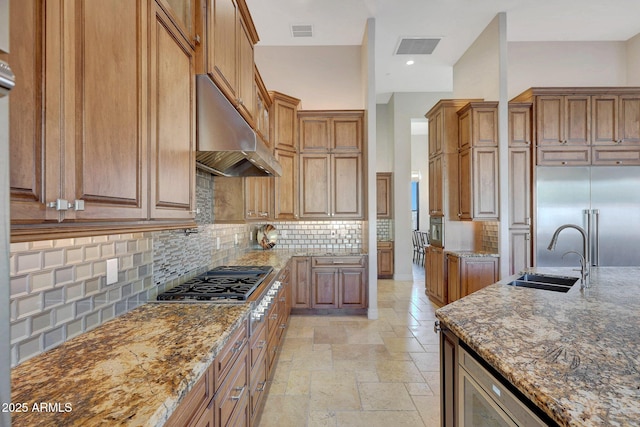 kitchen with sink, decorative backsplash, dark stone countertops, and appliances with stainless steel finishes