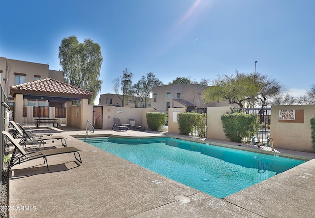 community pool featuring a patio area and fence