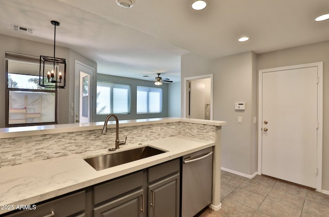 kitchen featuring a sink, visible vents, stainless steel dishwasher, gray cabinets, and backsplash