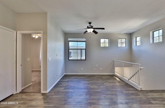 spare room featuring ceiling fan, baseboards, and wood finished floors