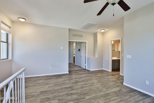 empty room with baseboards, visible vents, and wood finished floors