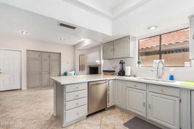 kitchen with sink, stainless steel dishwasher, gray cabinets, and kitchen peninsula