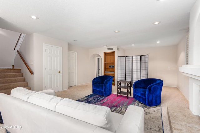 living room with a large fireplace and light carpet