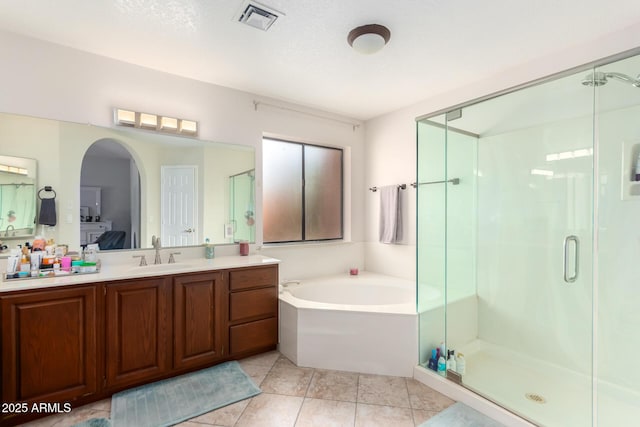 bathroom with a textured ceiling, vanity, tile patterned floors, and independent shower and bath