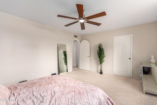 carpeted bedroom featuring a textured ceiling and ceiling fan