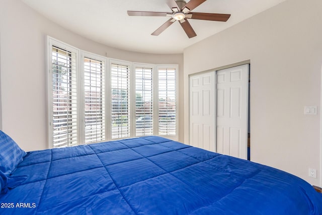 bedroom with multiple windows, a closet, and ceiling fan