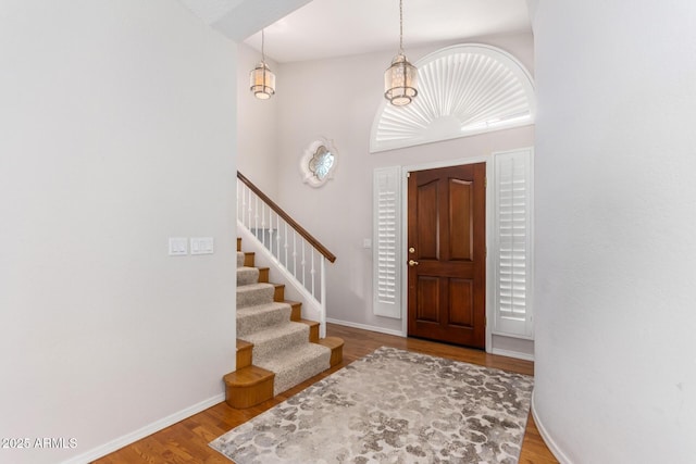 foyer entrance featuring hardwood / wood-style floors and a towering ceiling