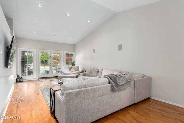 living room featuring lofted ceiling, hardwood / wood-style flooring, and french doors