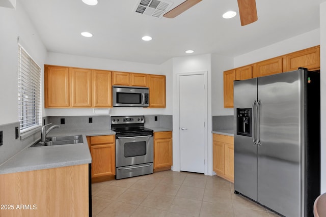 kitchen featuring ceiling fan, appliances with stainless steel finishes, light countertops, a sink, and light tile patterned flooring