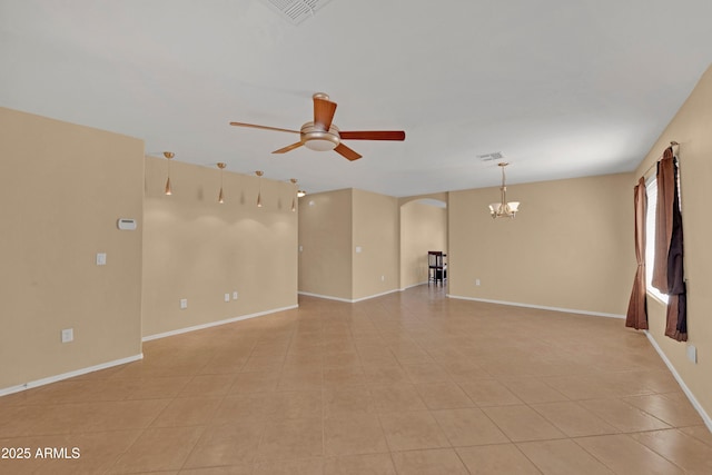 empty room with visible vents, arched walkways, baseboards, and ceiling fan with notable chandelier